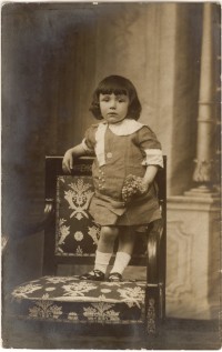 Kind mit Blumen auf Stuhl